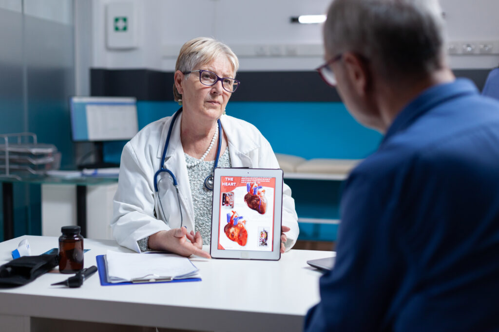 Heart Surgery in Turkey: A Safe 2025 Lifesaving Guide 2 physician explaining cardiology diagnosis with image heart organ tablet patient general practitioner showing illustration cardiovascular system anatomical structure man